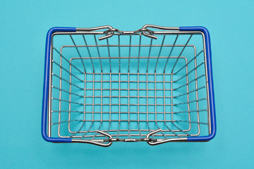 top view of shopping basket on blue background with some copy space