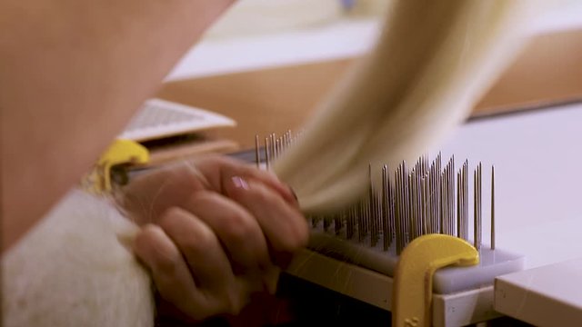 Wig Hair Combing. Wig production, female hands close-up.