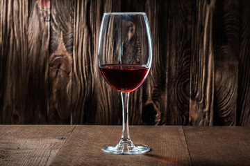 wineglass with red wine on vintage wooden background