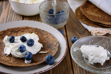 Thin rye tortilla stuffed with soft curd cheese like riccott with blueberries