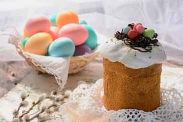 Easter cake next to colored eggs and branches of willow twig