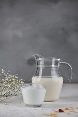 Dairy products, milk, yogurt, sour cream, kefir, in a glass and a jug. Vertical