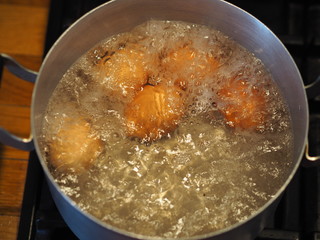 Homemade food. Chicken eggs are cooked in a saucepan over a fire. Preparing a filling for pies.