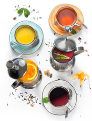 Hot tea, drinks in a teapot, cups with sea buckthorn, rosemary, orange, black tea. Assorted, a lot. Top view, white background.