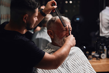 young maste cutting the odd hair, close up side view photo