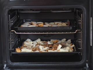 Home cooking. Dry bread crumbs in the oven on a black baking sheet. Vegetarian. Christian fasting.