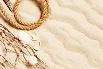 Fototapeta na wymiar Rope, shells and net on the sand, travel summer background