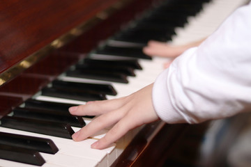 The piano close up. Black and white keys.Hands of a child playing the piano