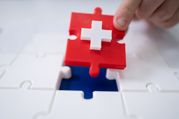 Obraz premium Man's Hand Solving Jigsaw Puzzle