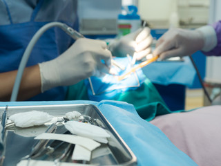 Selective focus dental equipment for dentist and blurry dentist examining patient tooth on dental chair at dental department.Medical mouth and tooth health care concept.