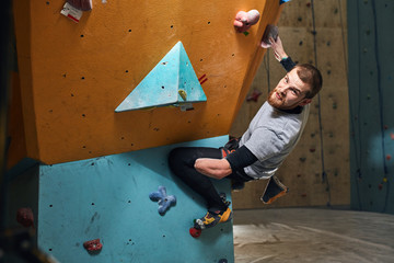 Athletic young male mountaineer trains hard despite his physical disability, enjoys his bouldering...
