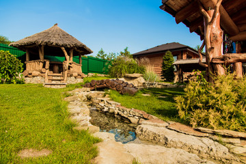 Fototapeta na wymiar landscaping of the courtyard, wooden cottage in nature