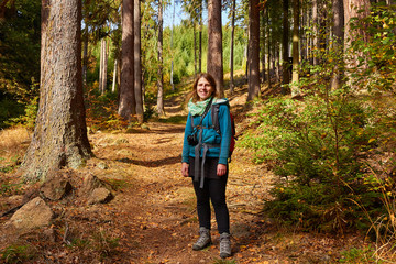 Frau lächelt in die Kamera und steht im Wald