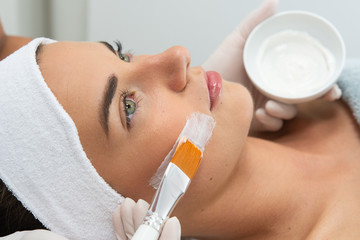 Dermatolog wykonuje zabieg leczniczy na twarzy kobiety. Maska w salonie kosmetycznym. Kosmetyczka...
