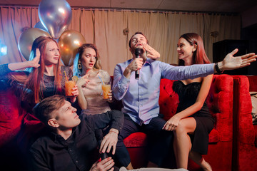 young caucasian people in trendy modern karaoke bar. Party makers. Celebrating birthday, holidays concept