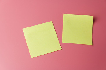 Obraz na płótnie Canvas Two yellow sticky note reminders on a red background