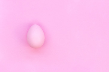 Top view Happy Easter card concept with copy space. Pink chicken egg painted for Easter on a pink background
