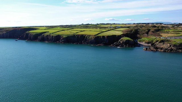 Aerial flying over ocean near Newtown Cove in Waterford, Ireland, truck right