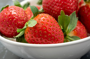 Close up of fresh strawberries in a white bowl. Macro shot with high magnification