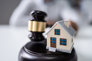 Judge Holding Gavel With House Model
