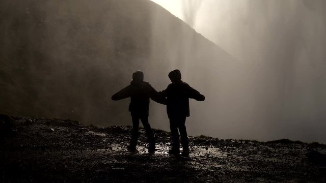 Travel Silhouette Concept Lifestyle teamwork. Group of tourists at waterfall.