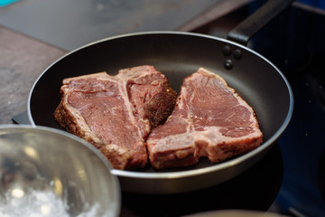 Raw Fresh Marbled Meat Beef on a grill pan ready for cooking. Man cooking beef steaks. a grill pan with beef steaks on kitchen