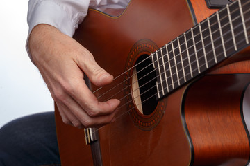 A man plays the guitar. Demonstration of different chords and manners of playing acoustic guitar