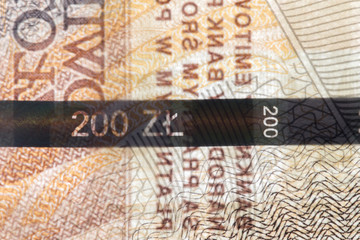 Plastic security strip inside 200 PLN banknote. Security strip on Polish banknote created to prevent counterfeiters.