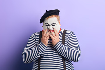 depressed young man closing his face with palm, feels bad,isolated blue background.