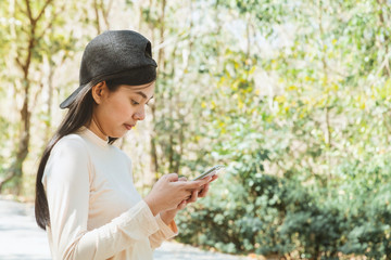 Young woman have outdoor adventure traveling in the forest on vacation using map on smartphone for searching direction and find way. Trail Trekking concept.