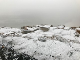 End of the world feeling at the cliffs of the Gullfoss Waterfall in Iceland: Frosted foggy winter landscape with rocks, cascades in the background and snow covered icelandic scenery in November