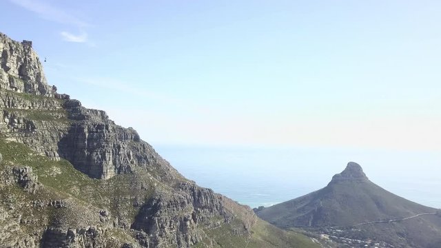 Epic majestic aerial sunny blue sky footage of spectacular scenic Lion's Head Mountain, rocky hills with cambrian erosion, Atlantic Ocean coast panorama in Western Cape, Cape Town, South Africa