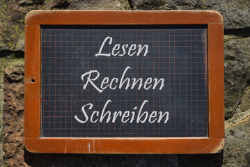 Alte Schiefertafel mit der Aufschrift: Lesen, Rechnen, Schreiben