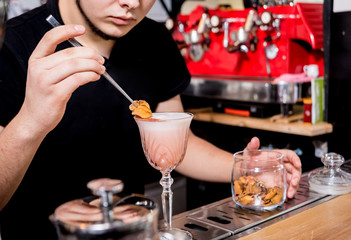 Bartender is making cocktail at bar counter. Fresh cocktails. Barman at work. Restaurant. Nightlife.