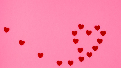 Small red hearts forming the shape of a large heart on a pink background.
