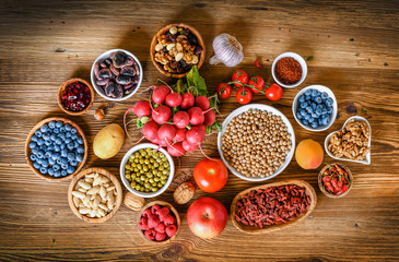 Obraz na płótnie Canvas Healthy superfood eating variety collection in bowls: vegetables, fruits, berries, seeds, raw food, cereal, leaf vegetable on colorful background.