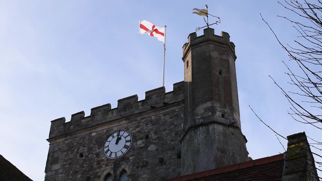 St Faith Church in Havant an ancient building displaying the flag of Saint George on a beautiful day in January. 