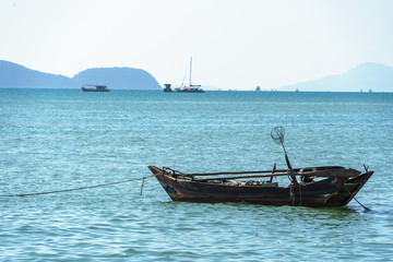 Beautiful seascape, view of the pier in Thailand. Fishing boat moored near the shore.