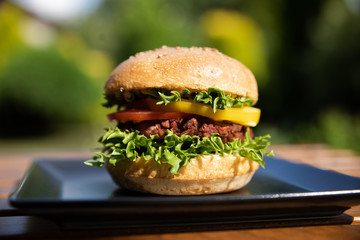 Vegan burger on a plate outside 