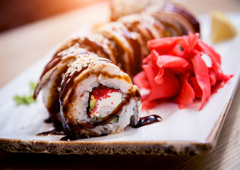 Sushi roll Green Dragon with avocado, ell, wasabi and ginger. Restaurant.