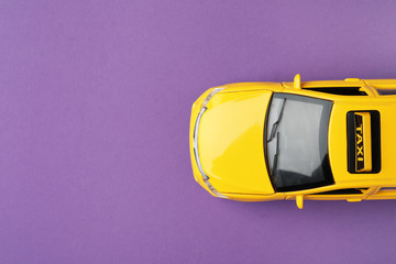 Yellow taxi car model on purple background, top view. Space for text