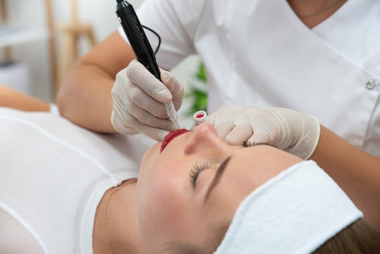 Kosmetyczka wykonuje makijaż permanentny ust. Usta po makijażu permanentnym w salonie urody. Mikropigmentacja ust zabieg w salonie medycyny estetycznej. 