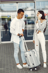 Couple in a airport. Beautiful brunette in a white shirt. Man in a white t-shirt