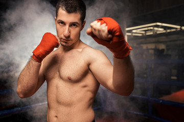 athlete boxer man with naked skin, wearing protective boxing gloves leaves agression in ring. Sporty lifestyle, box concept
