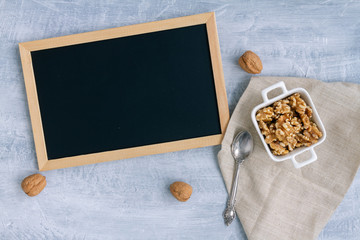 Walnuts in a white ceramic dish with copy space. Top view composition