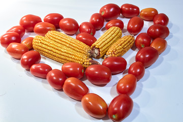 Tomates frescos y maíz dispuestos en forma de corazón.