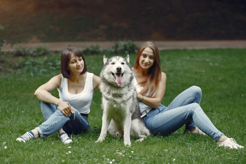 Beautiful girls in a white t-shirt. Women in a summer park. Lady with a dog