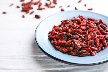 Dry goji berries on white wooden table, closeup