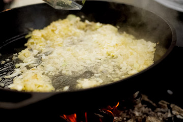Roasting onions in pan with oil on fire.