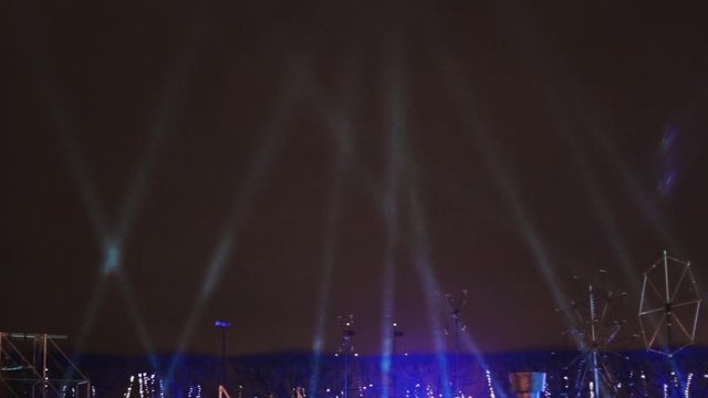 spotlights in the sky shine on stage rain